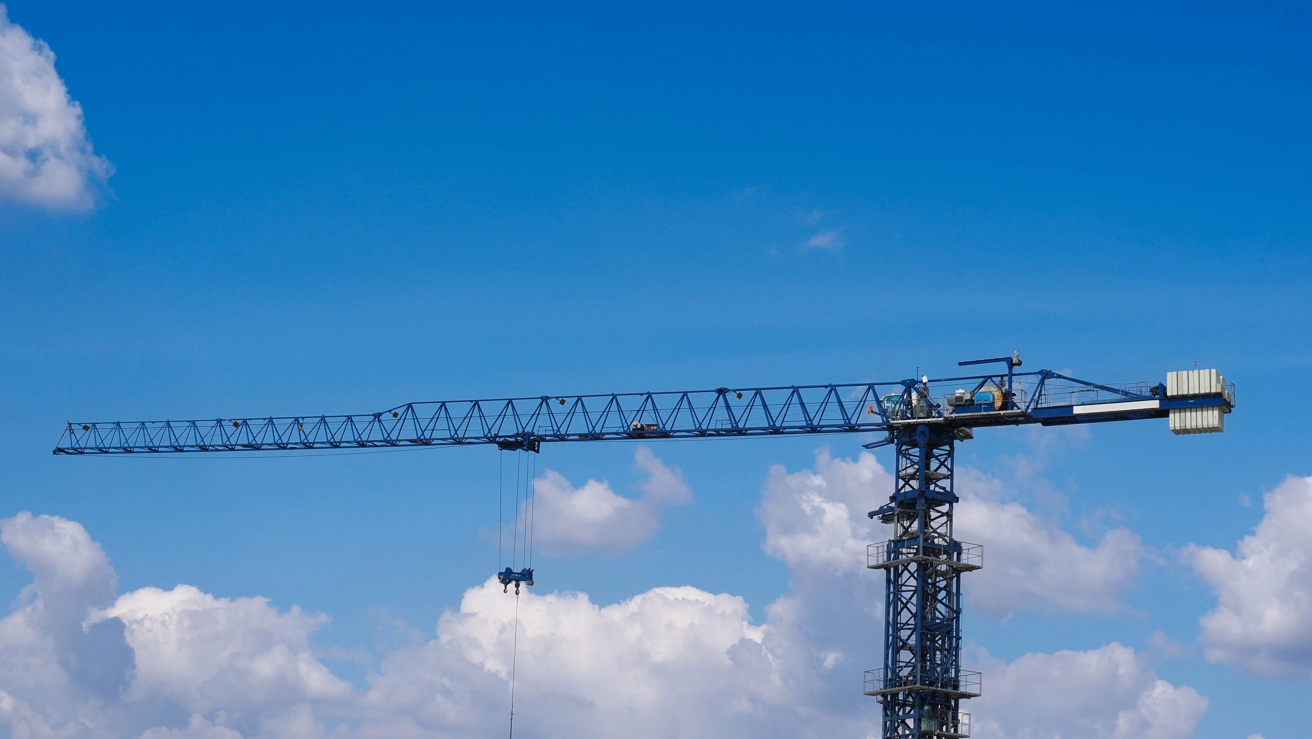 Tower crane at a construction site under a blue sky