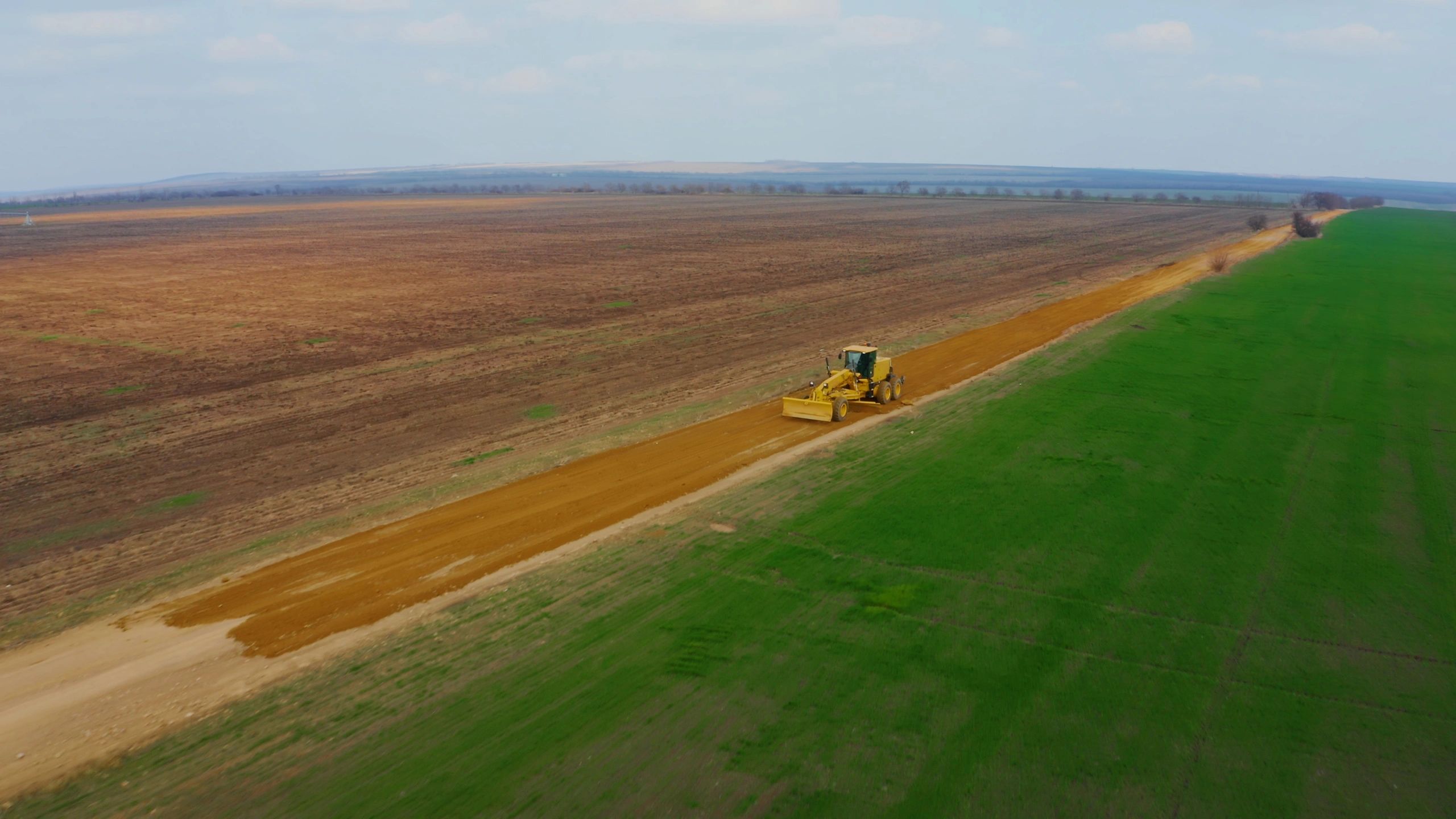 Motor grader working on road construction for infrastructure project