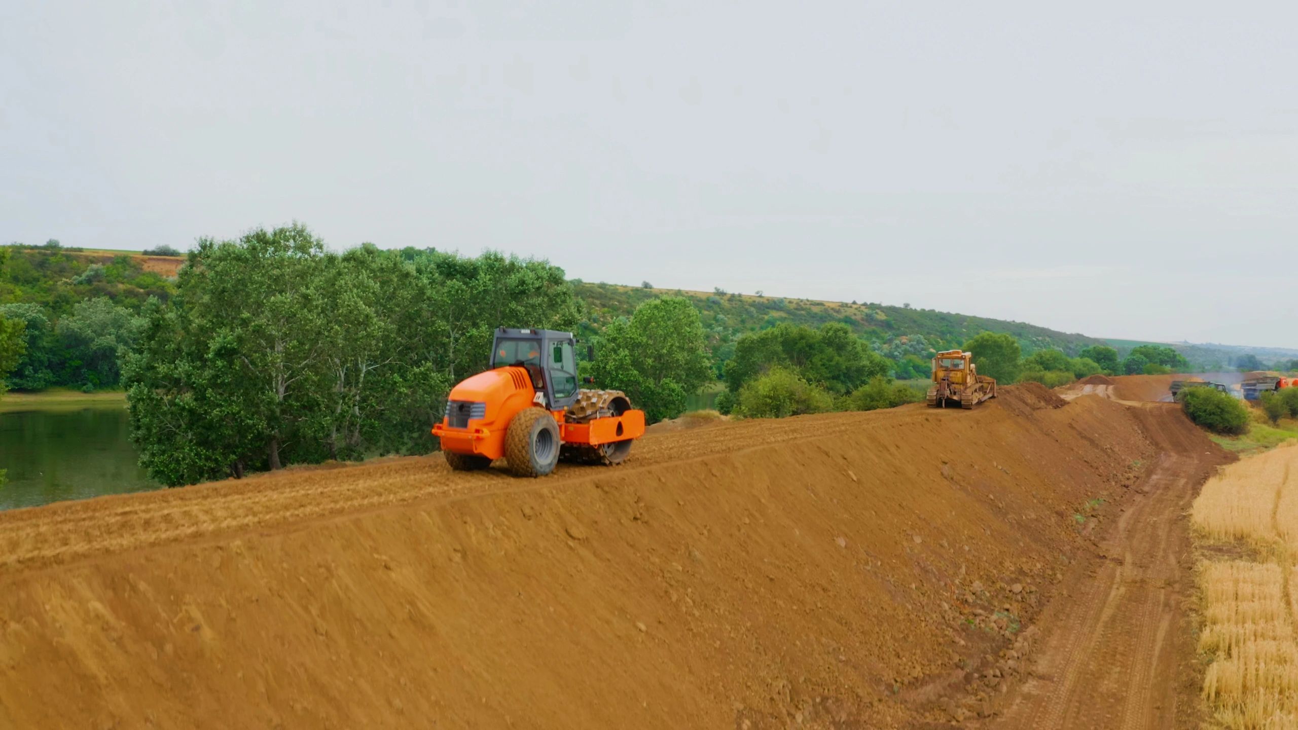Road roller compacting soil for a new road project